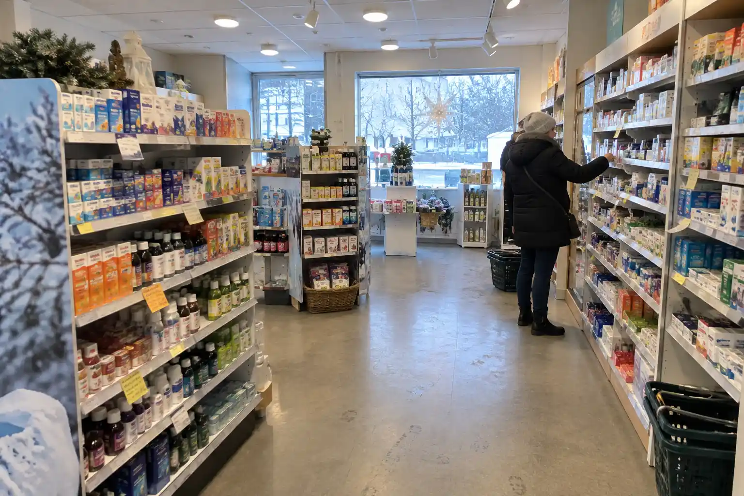 Kund i kappa browsar bland förkylningsmediciner i apotekshylla, tema kur mot förkylning?